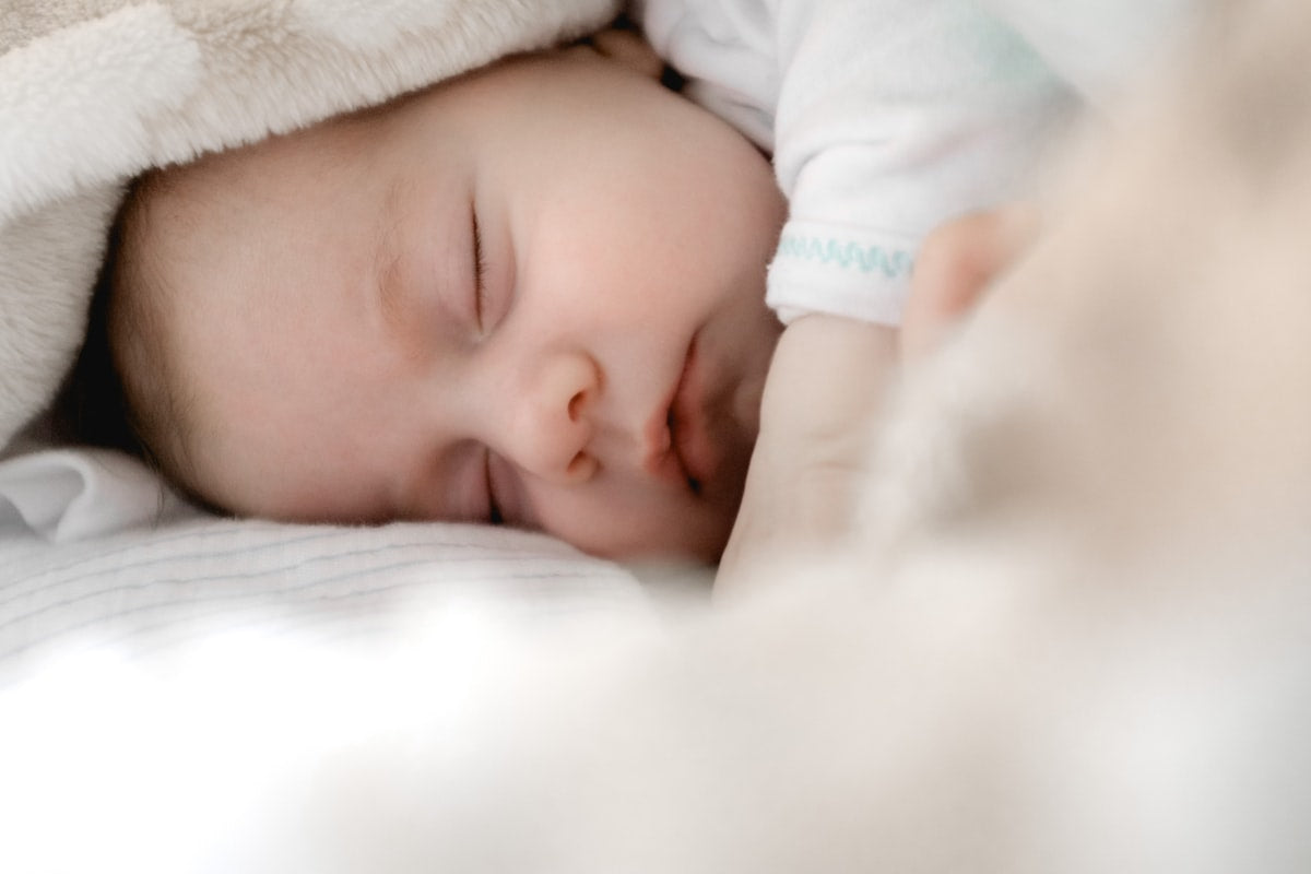 Madre sonriente sosteniendo con cariño a su bebé recién nacido en casa