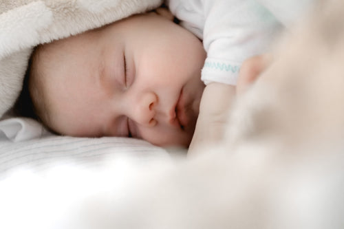 Madre sonriendo mientras sostiene a su bebé recién nacido · Ayuda de 1.000€ por nacimiento · BabyOrca